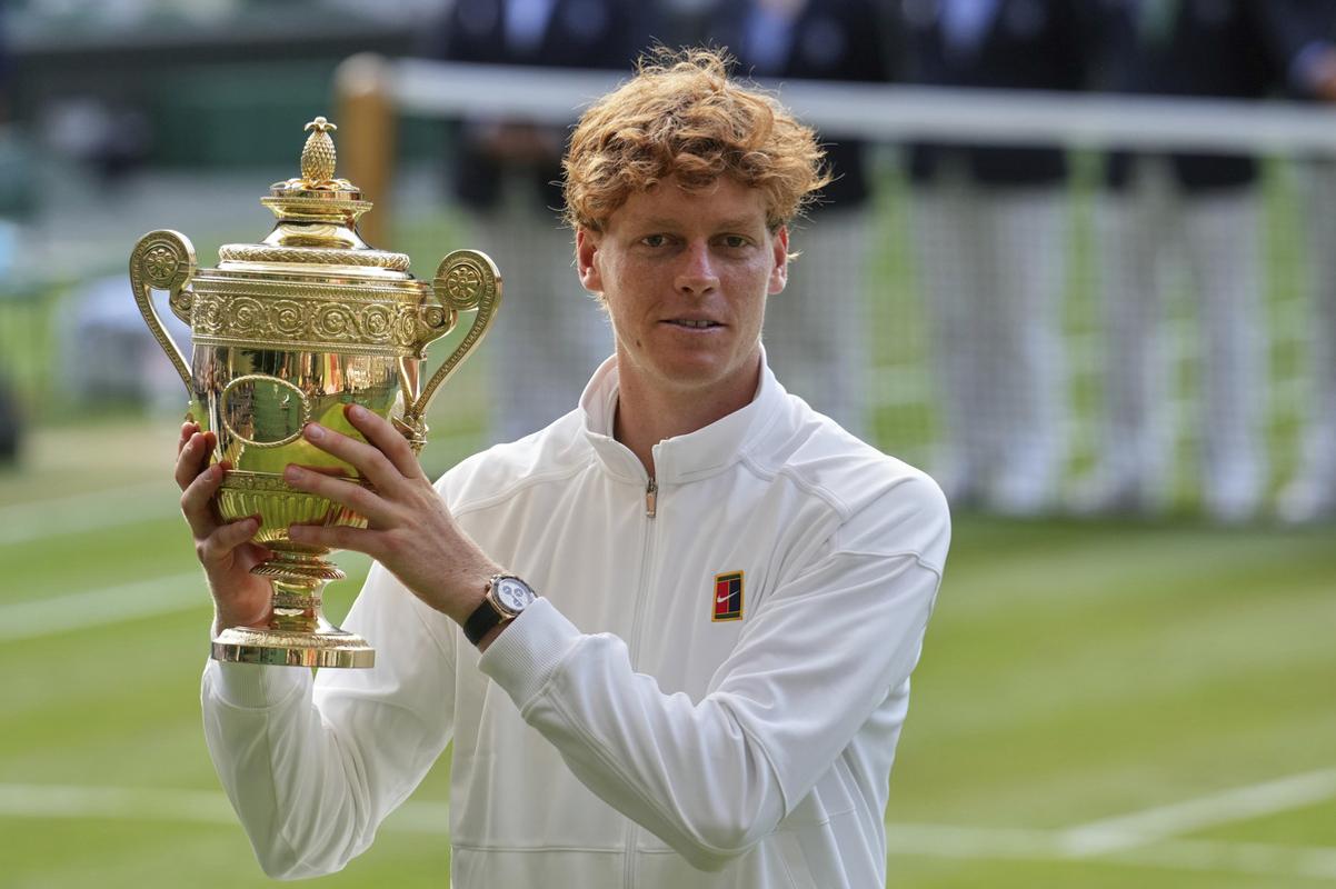 Taliansky tenista Jannik Sinner pózuje s trofejou po víťazstve nad Španielom Carlosom Alcarazom vo finále mužskej dvojhry na grandslamovom turnaji vo Wimbledone.