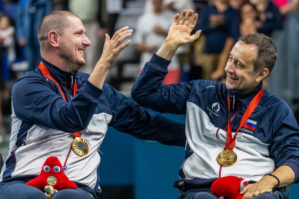 Na snímke slovenskí reprezentanti v parastolnom tenise Peter Lovaš (vľavo) a Ján Riapoš pózujú so zlatými medailami z paralympijských hier 2024.