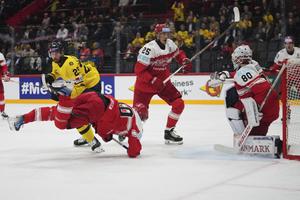 Dánsky hráč Anders Koch (vľavo dole) padá na ľad pred Švédom Marcusom Petterssonom (vzadu vľavo) v zápase o 3. miesto Švédsko - Dánsko na MS 2025 v hokeji.