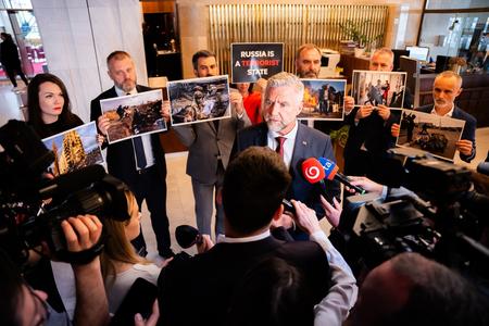 Smer MP Tibor Gašpar talks to the press, while a group of opposition MPs protest against the Russian ambassador's planned visit to the Slovak parliament on May 7, 2024.