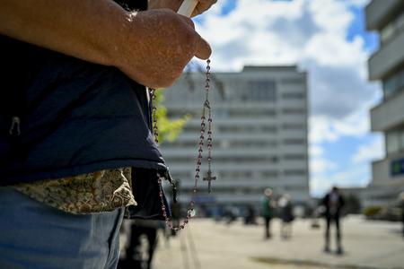 Чоловік молиться, тримаючи прапор Словаччини, біля лікарні  Рузвельта, де проходить лікування прем’єр-міністра Словаччини Роберта Фіцо в Банській Бистриці