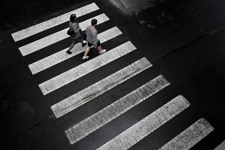 People cross a pedestrian crossing outside the F. D. Roosevelt University Hospital, where Slovak Prime Minister Robert Fico, who was shot and injured, is being treated, in Banska Bystrica, central Slovakia, Friday, May 17, 2024.