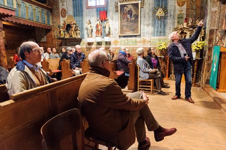 Peter Kresánek, right, providing explanations to tourists in the UNESCO-listed 15th century wooden church in Hervartov, eastern Slovakia.