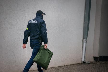 A NAKA officer pictured during a 2022 investigation into criminal allegations against Robert Kaliňák (Smer), who is now defence minister, and Smer leader Robert Fico, who is now prime minister. Both were charged with crimes, but the charges were later dropped.