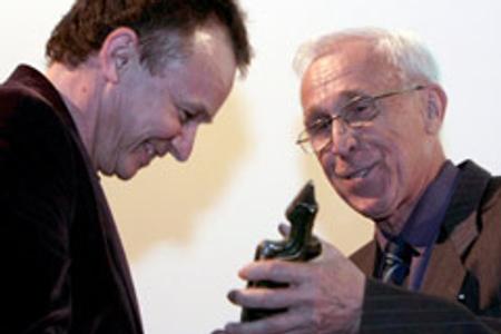 Director Juraj Nvota (left) receives the Igric Award for his film, Muzika, from František Jurišič.