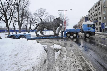 The bronze lion being taken for a 'face-lift' before being placed in its new location near the new building of the National Theatre.