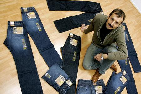 General director of the Rica Lewis jeans showroom, Dominique Lanson, poses with bluejeans of cotton bought from impoverished African growers at well above the market rate are making their debut in Europe. Their French manufacturer, Rica Lewis, billed them as the world's first fair trade jeans in 2006.