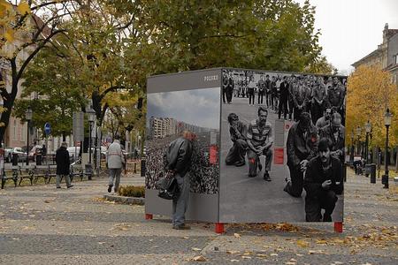 People stop to look at the photos on, and also inside, the outdoor display cubes. 