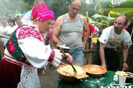 Slovaks in traditional costume enjoy halušky.