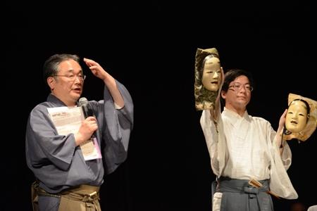 Head of Yamamoto Noh theatre and his apprentice explain masks in a workshop.