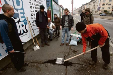 Volunteers repair the sidewalks.