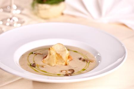 Potato mushroom cream soup served with chive oil and potato chips
