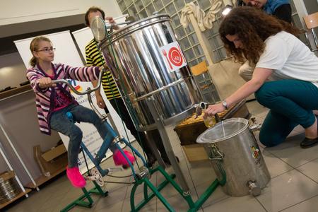 extracting honey by connecting a stationary bike with a stainless steel honey extractor.
