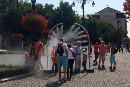 People enjoy the misting system at Hviezdoslavovo square.