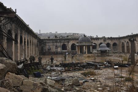 Syrian troops and pro-government gunmen marching walk inside the destroyed Grand Umayyad mosque in the old city of Aleppo, Syria.