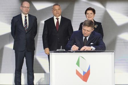 Slovakia's Prime Minister Robert Fico signs the Warsaw Declaration, as his counterparts from Czech Republic, Bohuslav Sobotka (l), Hungary, Viktor Orbán (center), and Poland, Beata Szydlo (r), watch behind.