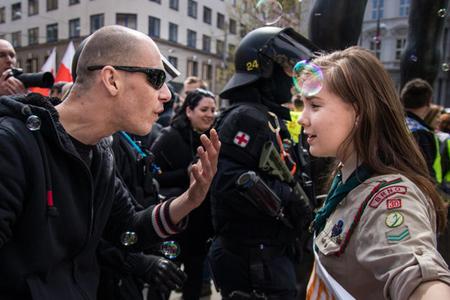 The photograph of Girl Scout Lucie Myslíková, aged 16, confronting an extremist was taken in the Czech city of Brno, during the May 1 protest called Those Who Play Do Not Salute the Nazi Way. The participants tried to block a neo-Nazi march, in a light-hearted way. 