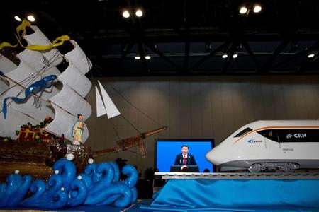 Chinese President Xi Jinping speaking at the opening of the Belt and Road Forum is displayed on a big screen near decorations depicting a modern high speed train and Chinese Admiral Zheng, who commanded expeditionary voyages across Asia and East Africa in the 15th century, in Beijing on May 14. 