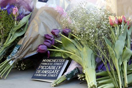 Floral tributes are laid out in Manchester, England, on May 23, 2017, the day after the suicide attack at an Ariana Grande concert that left 22 people dead as it ended on May 22 night. 