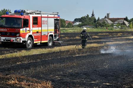 A fire fighter puts out a fire in the field in the town of Vojčice, eastern Slovakia, on July 16, 2019. 