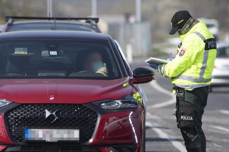 A police officer checks a vehicle in Bratislava during the coronavirus outbreak on April 6, 2020. 