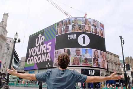 BBC Radio 1's Greg James looks at a huge billboard in London after he completes his global 'Up Yours Corona' mission on July 29, 2020. 