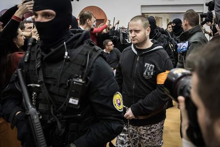Miroslav Marček is escorted to the courtroom.