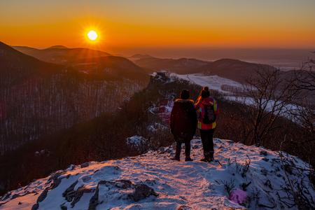 Tourists watch the sunset over the ruins of the Ostrý Kameň castle near the village of Buková, Trnava Region, on February 16, 2021. Scroll down to watch a video.