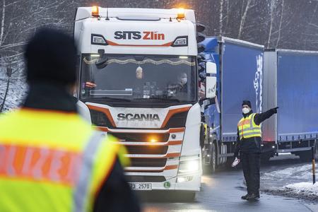 Police officers check vehicles in a parking lot shortly after the German-Czech border in Waidhaus, Germany, Tuesday, Feb.16, 2021. Germany's tightened entry rules at the border with the Czech Republic, Slovakia and Tyrol to protect against dangerous variants of the coronavirus came into force two days ago. 