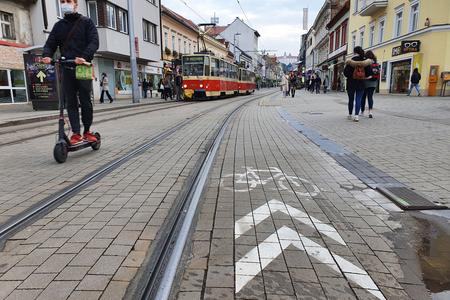 Cyclists and scooter riders wave their way on Obchodná Street.