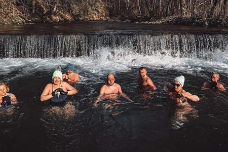 People swim in the Zázrivka stream in Lúčivná.