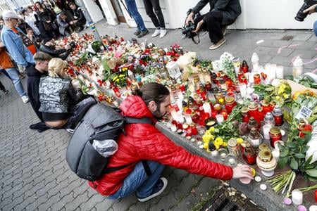 People lighting candles in front of the Tepláreň LGBT+ venue on the Zámocká Street.