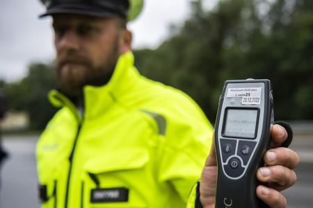 A police officer carrying out an alcohol breathing test.