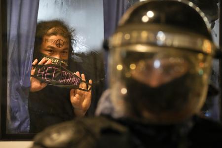 A detained demonstrator shows a sign 'No War!' from a police bus in St. Petersburg on February 24, 2022. 