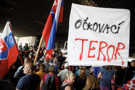 "Vaccination terror" reads one of the banners.