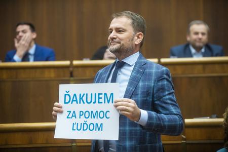 Finance Minister Igor Matovič (OĽaNO) holds a "Thank you for helping people" banner in parliament on December 22, 2022.