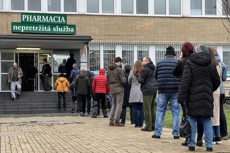 People waiting in line in front of a pharmacy in Bratislava due to increase of respiratory disease cases.