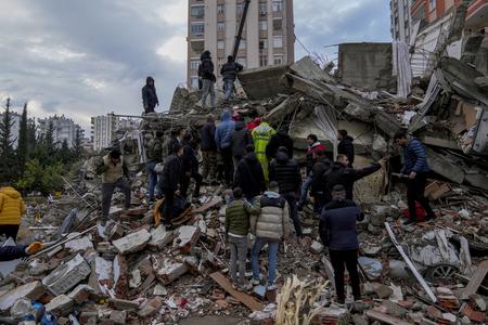People and emergency teams search for people in a destroyed building in Adana, Turkey, on Monday 6, 2023. 