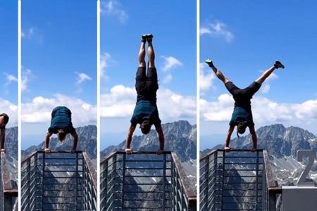 A man does a handstand on Lomnický Peak.