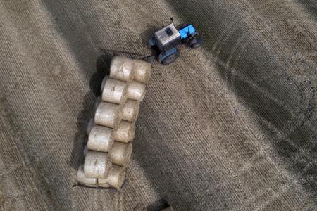 A tractor collects straw on a field in a private farm in Zhurivka, Kyiv region, Ukraine, Thursday, Aug. 10, 2023.