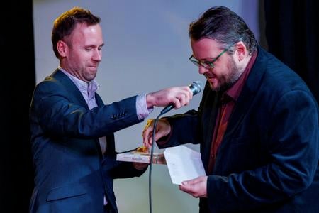 Michal Duchoň, head of the Bratislava City Archives, right, "christened" the book with archival dust. 