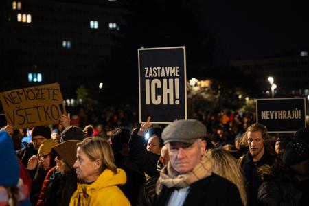 People take part in the opposition-organised protest outside the Government Office in Bratislava on December 7, 2023, holding up different slogans: "You can't do everything!", "Let's stop them!" and "They won't win!".