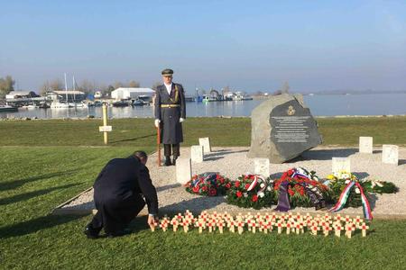 An attendee leaves a commemorative cross at the memorial in Čunovo on November 10.