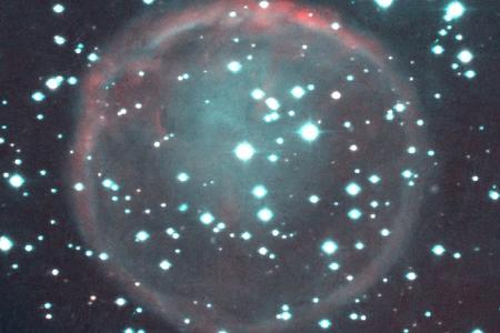The WeSb1 planetary nebula. The regions in red are hydrogen, while oxygen is represented by blue and green colours. The picture was taken from the NOT and INT telescopes on the Canary Islands. The central star of the nebula can be seen slighty above the middle of the picture.