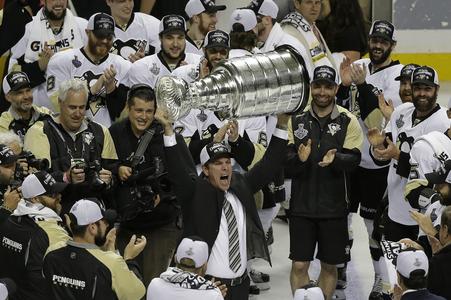 Na archívnej snímke z 12. júna 2016 tréner Pittsburghu Penguins Mike Sullivan zdvíha Stanleyho pohár po šiestom zápase finále zámorskej NHL proti San Jose Sharks