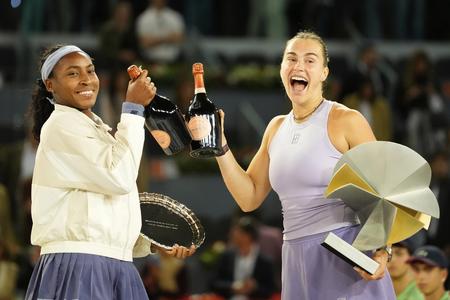Bieloruská tenistka Arina Sobolenková (vpravo) pózuje s trofejou po výhre proti Američanke Coco Gauffovej (vľavo) vo finále ženskej dvojhry na turnaji WTA 1000 v Madride