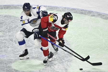Fínsky hráč Mikko Lehtonen (vľavo) bojuje o puk s Rakúšanom Lukasom Kainzom v úvodnom zápase A-skupiny Rakúsko - Fínsko na MS 2025 v hokeji.