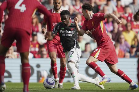 Bukayo Saka (Arsenal) v obklopení hráčov Liverpoolu.