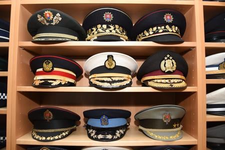 A collection of police, firefighter, military and naval caps.