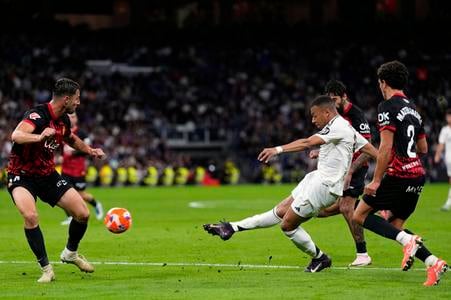 Slovak defender Martin Valjent (left) of RCD Mallorca watches as Real Madrid’s Kylian Mbappé (second from right) fires a shot on goal during the La Liga match between Real Madrid and Mallorca in Madrid on Wednesday, 14 May 2025.